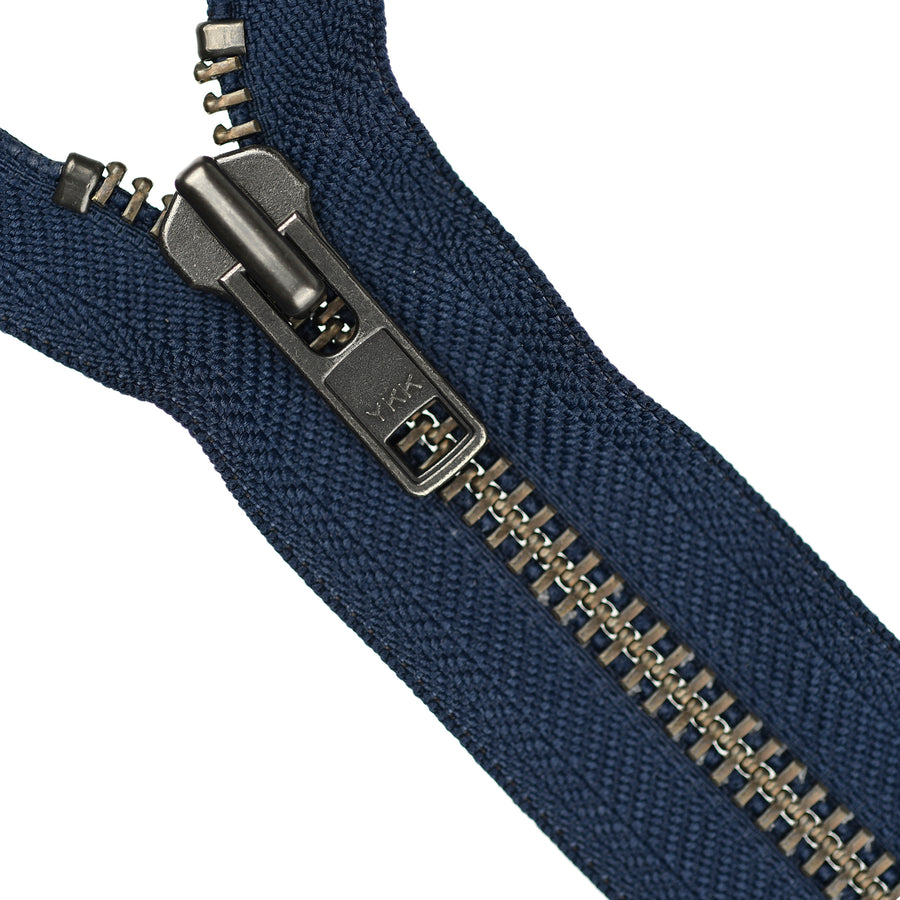 Close-up of a navy blue zipper with a metal pull on a white background