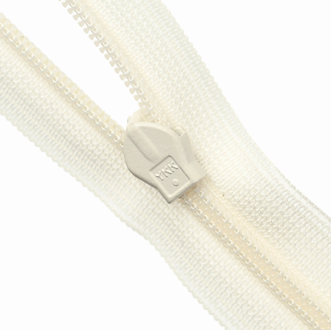 Close-up of an ivory zipper on a white background