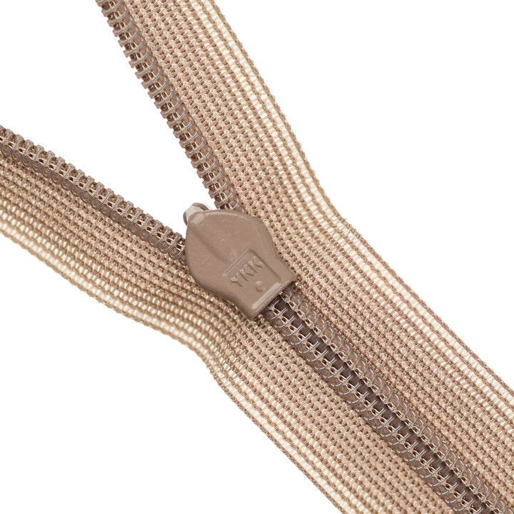 Close-up of a beige zipper on a white background