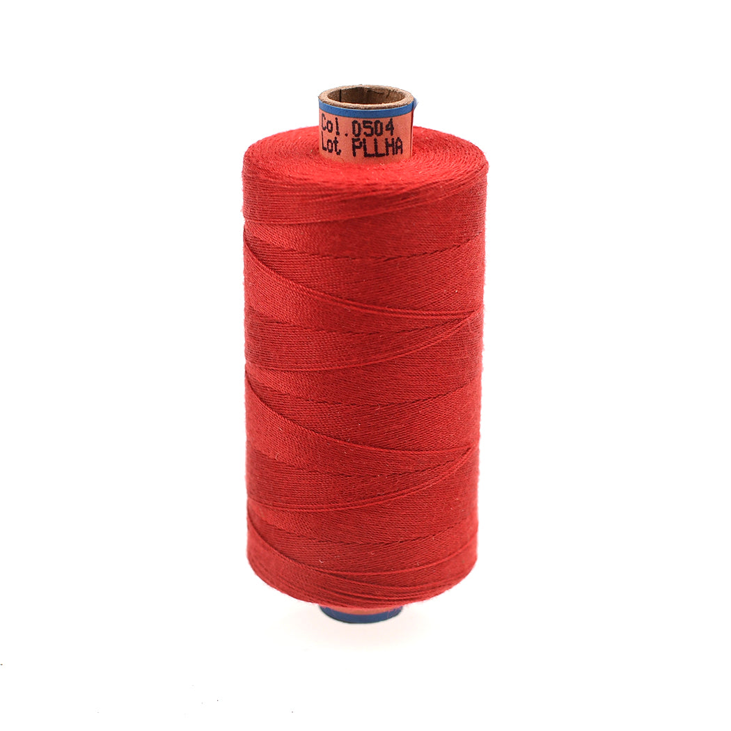 Red spool of thread on a white background