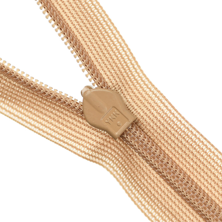 Close-up of a beige invisible zipper on a white background