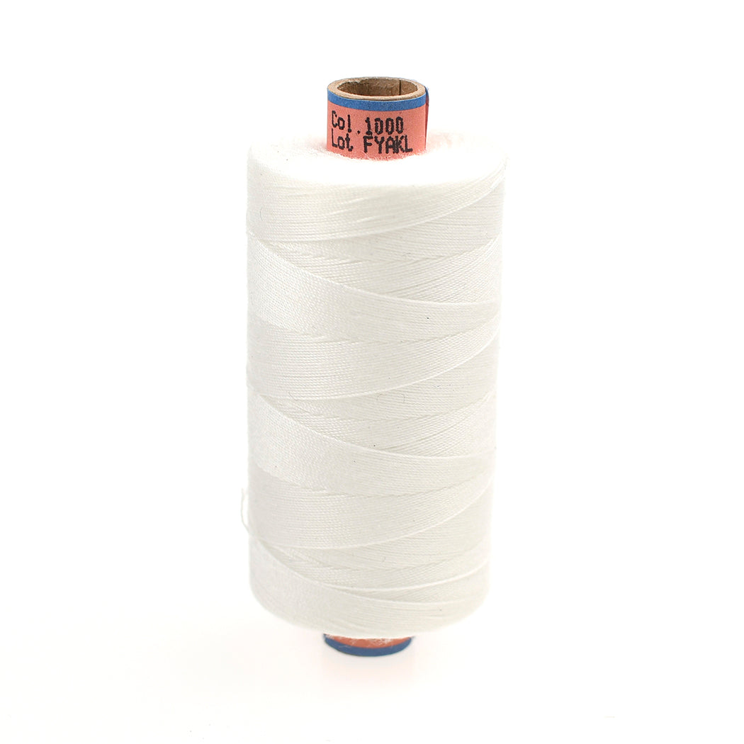 Spool of white thread on a white background
