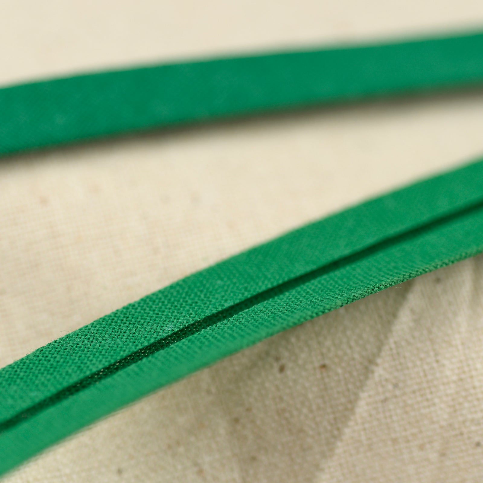 Green bias binding on a calico fabric background