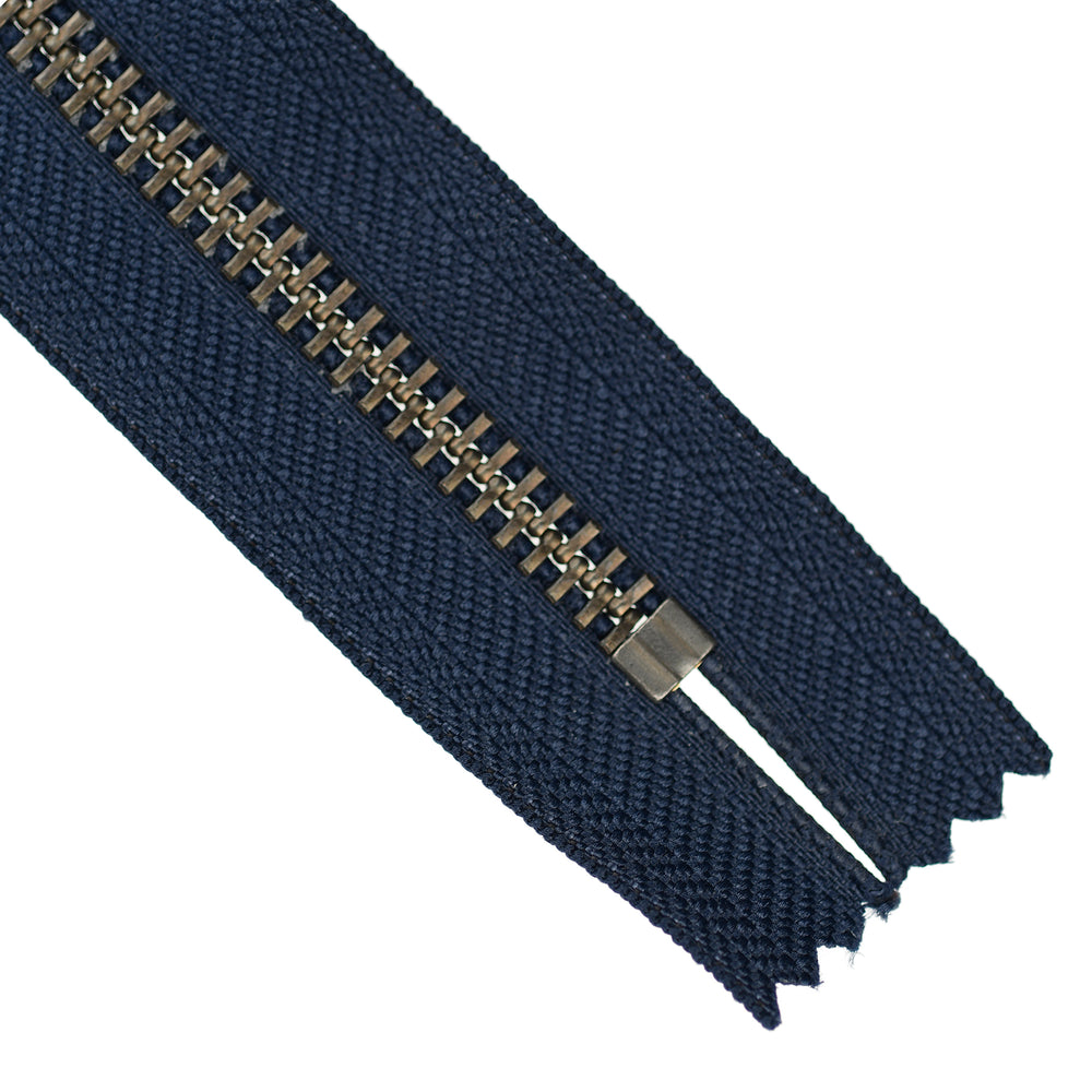 Navy blue zipper with a metal pull on a white background