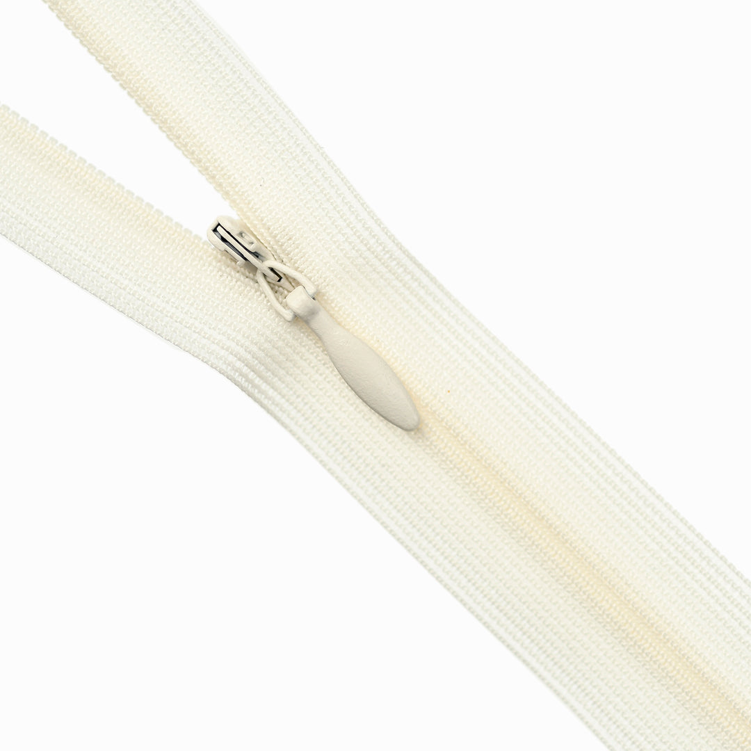 Close-up of an ivory zipper on a white background