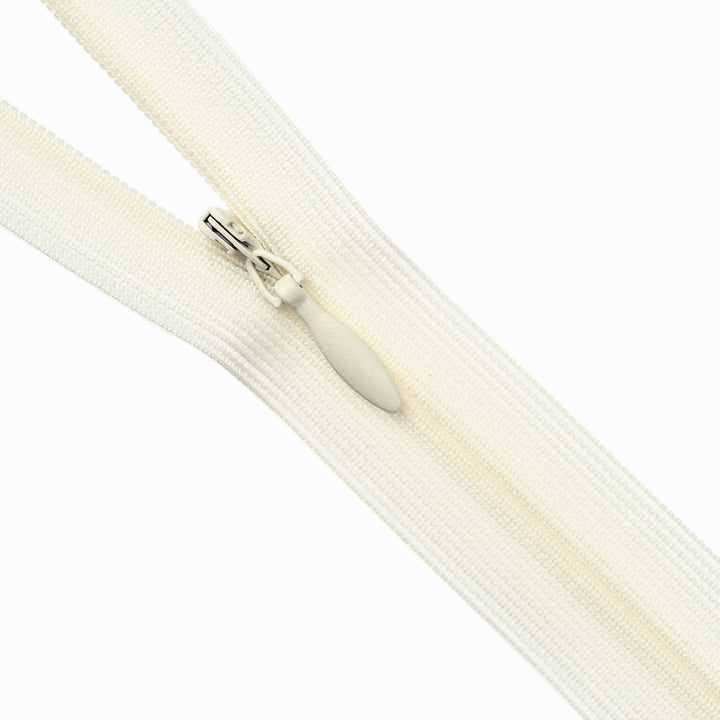 Close-up of an ivory zipper on a white background