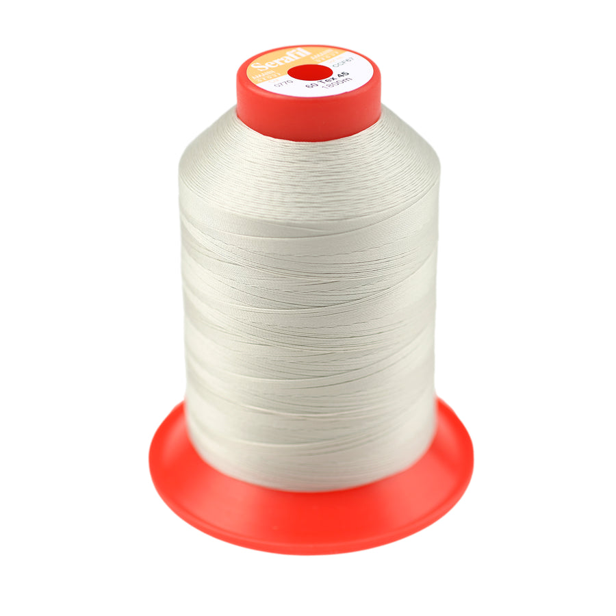 Spool of off-white thread against a white background